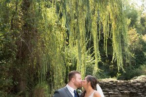 Bride and groom kissing beneath the willow tree