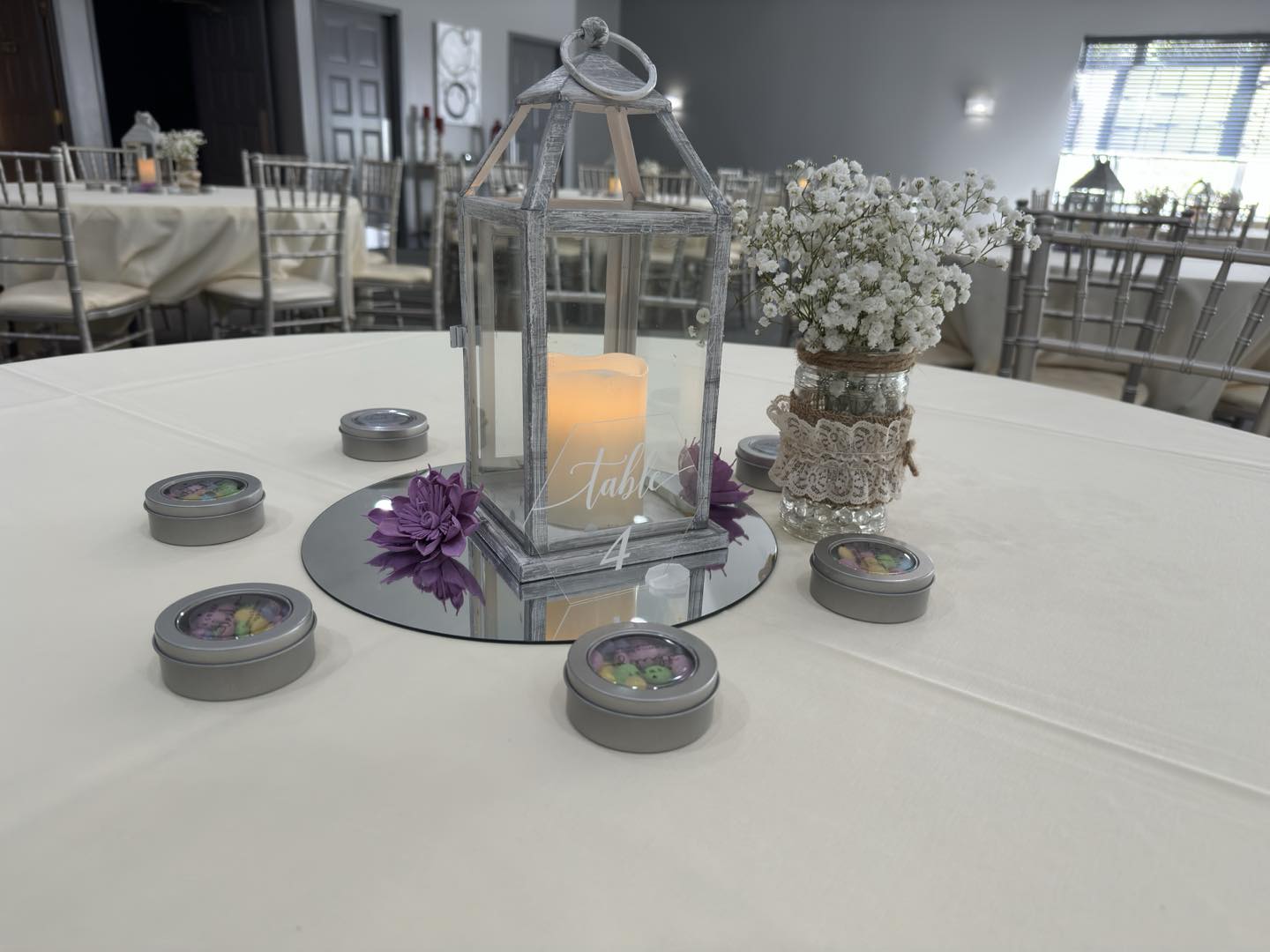 Reception table with a white lantern and baby’s breath centerpiece
