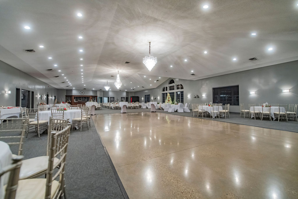 Polished wooden dance floor and round tables with white linens