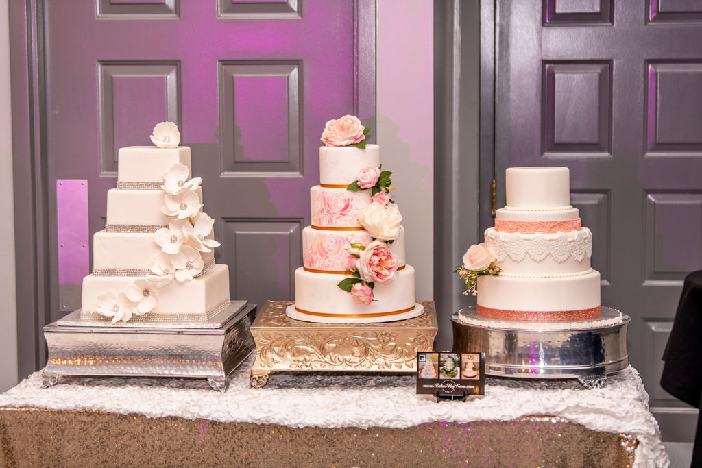Three tiered wedding cakes on a gold sequined table